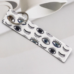 Detail of faux leather keychain with blue evil eye print and silver metal ring