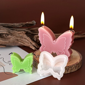 Detailed 3D butterfly silicone mold and finished handmade aromatherapy candles on wood