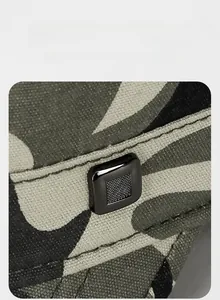 Macro shot of durable camouflage canvas fabric with a square metal logo plate