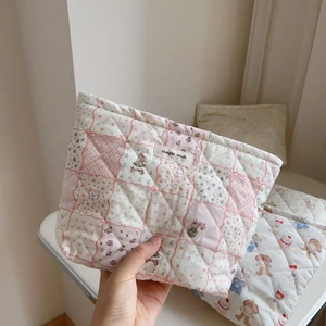 Close-up of quilted floral cosmetic bag with cartoon rabbit and simple wish tag