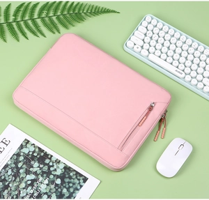 Pink laptop sleeve detail with diagonal zipper front pocket on a light green background