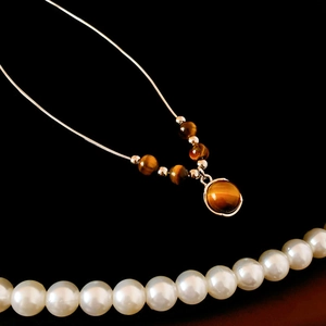 Vue détaillée du collier vintage avec pendentif en œil de tigre et chaîne argentée élégante