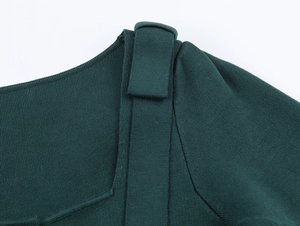 Detail of square neckline and decorative shoulder bows on dark green knit top