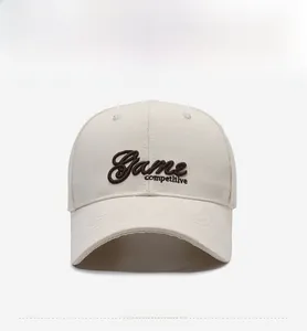 Detail of premium brown letter embroidery on a cream cotton baseball cap with ventilation holes