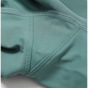 Macro detail of high-density dark teal yoga pants with professional flatlock stitching