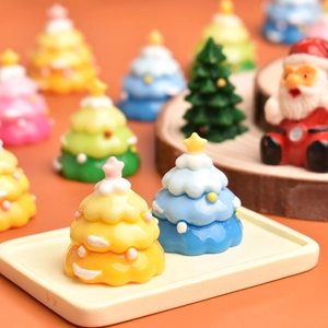 Detailed macro view of yellow and blue miniature resin Christmas trees with snow