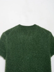 Dettaglio del maglione in maglia mohair verde scuro con texture morbida e girocollo