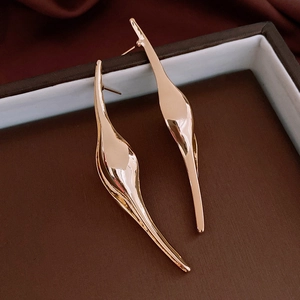 Macro shot of minimalist gold streamlined wave earrings with high polished glossy finish