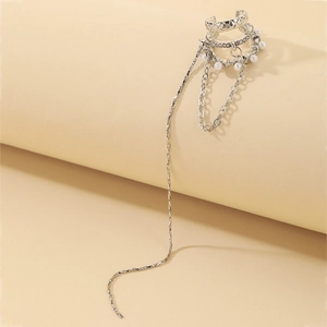 Close-up of silver multilayer ear cuff with rhinestones, faux pearls and long tassel chain