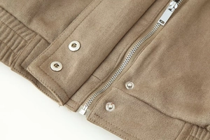 Detail of tan faux suede jacket featuring silver metal zipper and snap button closure