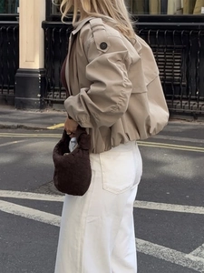 Women casual khaki button-down lapel short jacket with woven handbag in urban street style