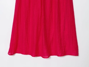Vue détaillée du tissu plissé en mousseline rouge avec une texture verticale très douce