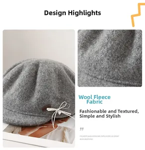 Detail of wool fabric texture with bow and heart pendant on a gray beret hat