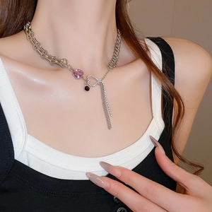 Detail of silver chain necklace with pink heart pendant and sparkling rhinestone tassels