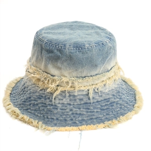 Detailed view of frayed edges and vintage light blue washed denim texture on a bucket hat