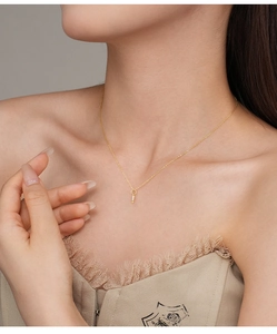 Detail of a minimalist gold S925 silver necklace with sparkling zircons on a model