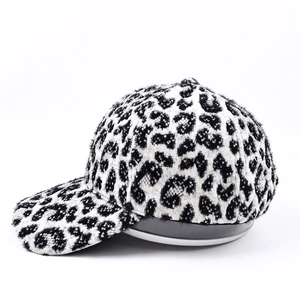 Gros plan sur la texture en fausse fourrure et l'imprimé léopard noir et blanc de la casquette