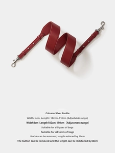 Detail of 4cm wide dark red leather bag strap with adjustable length and silver metal hooks