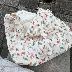 Detail of canvas tote bag with cartoon dog prints and simple wish woven label