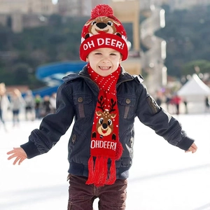 Détail d'un ensemble bonnet et écharpe de Noël rouge tricoté avec motif de renne