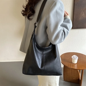 Retro black PU leather tote bag with adjustable strap shown on model in natural light