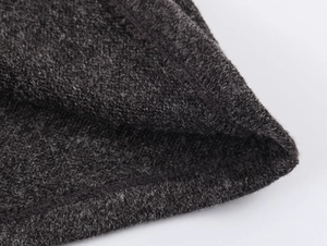 Gros plan sur un tricot gris foncé montrant la texture douce et les finitions de couture