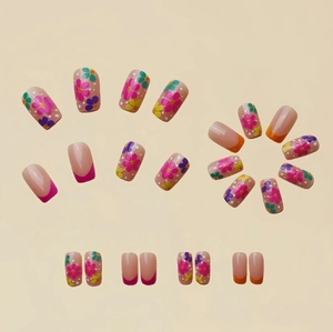 Faux ongles français avec motifs floraux colorés et pointes orange vif