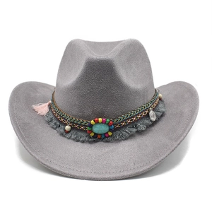 Détails d'un chapeau de cowboy gris avec pierre turquoise et glands de style bohème