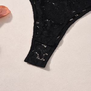 Detailed macro view of black floral lace stitching on stretch bodice with sheer patterns