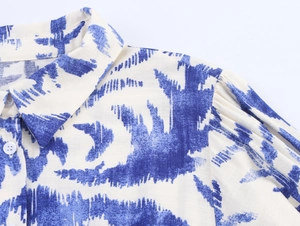 Detailed close-up of shirt collar and pleated shoulders with blue abstract prints