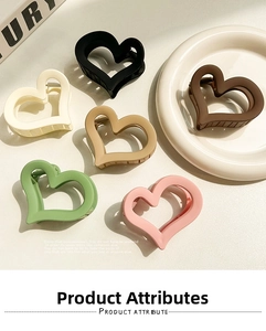Detail showing various colors of matte heart-shaped claw clips with metal spring