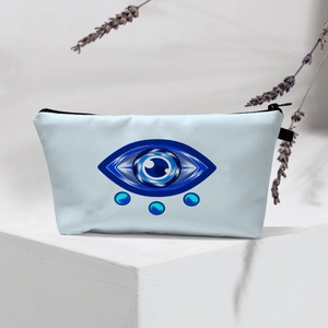 Detail of light blue Evil Eye makeup bag with top zipper on a minimalist display