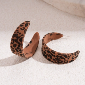 Detail of velvet C-shaped hoop earrings with brown leopard print and metal needle posts