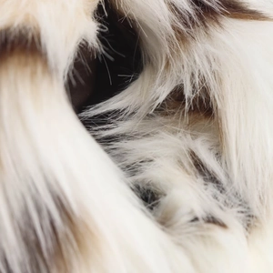 Detailed macro view of soft cream and brown faux fur texture with high-density long fibers