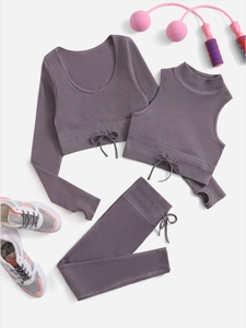 Close-up of ribbed knit texture on a three-piece yoga set with cross-tie waist detail