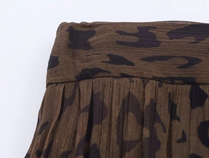 Dettaglio ravvicinato del tessuto con stampa animalier marrone e nera e pieghe