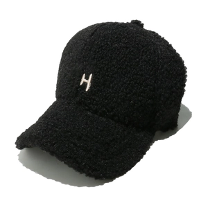 Détail d'une casquette de baseball noire en polaire avec broderie H blanche