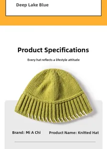 Close-up of grass green knit beanie with ribbed cuff and white decorative stitching
