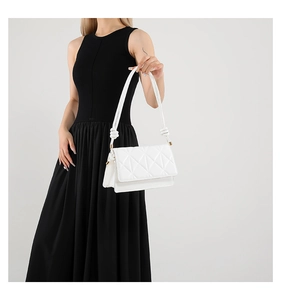 Detailed view of white quilted PU leather square bag with knot strap and gold hardware