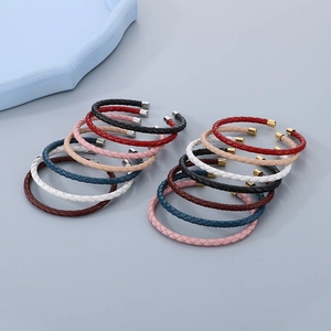 Varietà di braccialetti in pelle intrecciata con terminali in metallo in vari colori