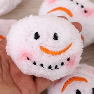 Plush white snowman snowballs with embroidered smiley faces for Christmas window display