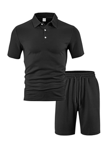 Dettaglio macro del tessuto nero a nido d'ape sul set polo e pantaloncini da uomo relax