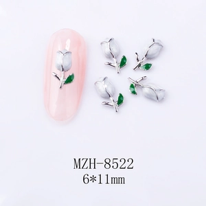 Close-up of 6x11mm white tulip nail charms with alloy base and green leaf detail