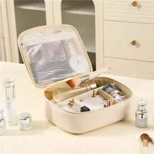 Large cream PU leather cosmetic bag with internal dividers and mesh pocket shown on a vanity