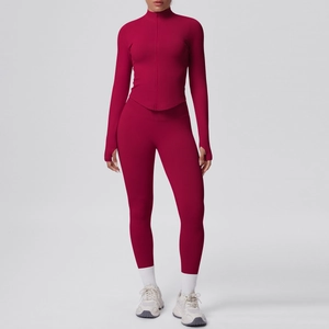 Dettaglio del top da yoga rosso scuro con zip, fori per i pollici e leggings a vita alta
