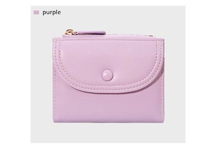 Primer plano de billetera corta morada con cuero sintético texturizado y costuras finas