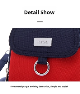 Close-up of red and blue oxford fabric bag featuring silver MDZL hardware and metal ring