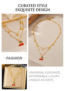 Detail view of double-layer gold chain necklace with red enamel cherry pendant