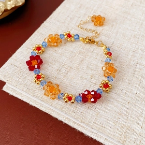 Détail du collier à fleurs en perles colorées avec fermoir mousqueton doré sur lin