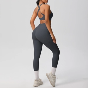 Detail of high-waist yoga leggings and cross-back sports bra in dark grey fabric
